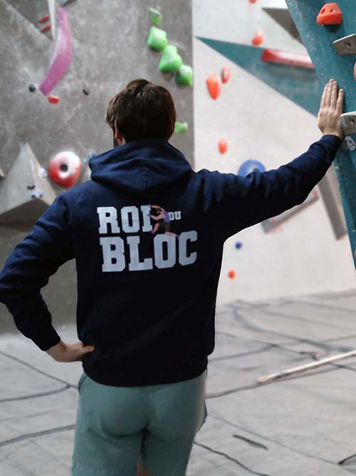 Homme de dos dans une salle de bloc portant le sweat à capuche bleu marine Roi du bloc