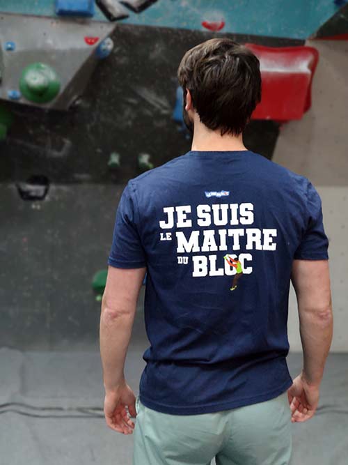 Homme de dos dans une salle de bloc portant le t-shirt bleu marine Je suis le maître du bloc