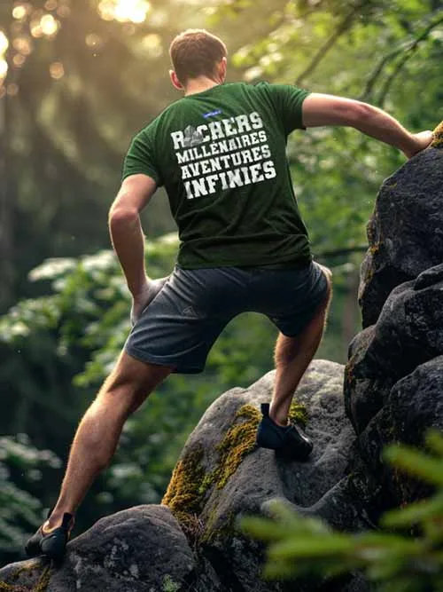 Homme de dos grimpant un rocher en forêt de Fontainebleau, portant le t-shirt vert forêt Rochers Millénaires, Aventures Infinies