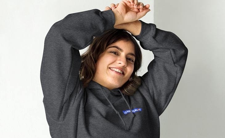 Femme de face portant un sweat à capuche gris foncé Le Roi du Bloc