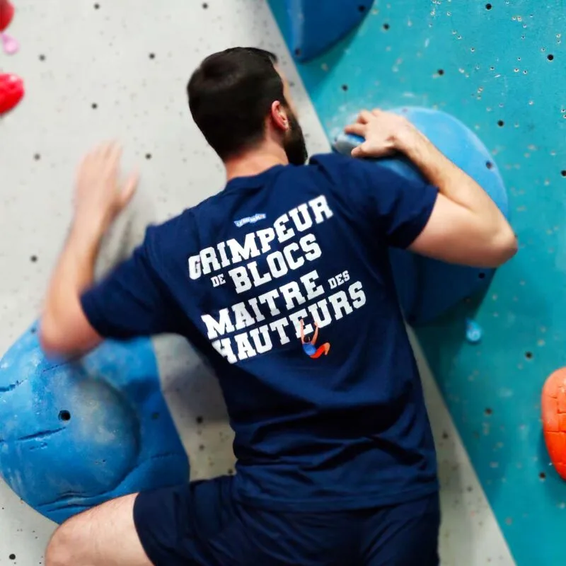 Homme de dos en train de grimper, portant le t-shirt bleu marine Grimpeur de blocs, Maître des hauteurs