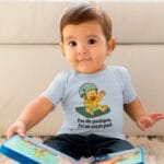 Bébé lisant un livre et portant le t-shirt "pas de panique, j'ai un crashpad" en bleu clair