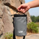 Sac à magnésie pour l'escalade gris tenu par la main