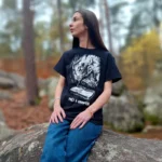 T-shirt Prêt à grimper porté par Mathilde assise sur un rocher à Fontainebleau