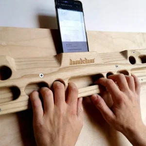 Grimpeur utilisant une poutre d’escalade en bois pour l’entraînement des doigts à la maison